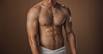 Body, abs and muscle of man in studio with space, biceps or pectoral with grooming on brown background. Skin, hygiene and strong male person with six pack, stomach and self care for cleanliness