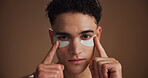 Skincare, eye pads and portrait of man in studio for beauty, natural or grooming for facial routine. Happy, cosmetics and person with collagen patches for dermatology treatment by brown background.