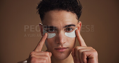 Buy stock photo Skincare, eye pads and portrait of man in studio for beauty, natural or grooming for facial routine. Happy, cosmetics and person with collagen patches for dermatology treatment by brown background.
