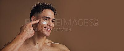 Buy stock photo Skincare, face cream and man in studio for natural, beauty or facial routine with hydration or moisturizer. Banner, mockup space and person with lotion for dermatology treatment by brown background.
