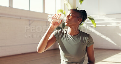 Buy stock photo Black woman, drinking and water bottle in studio for hydration, recovery or natural beverage. Female person, yogi or thirst with mineral liquid for fitness, rest or workout break in health club