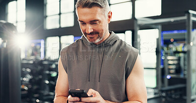 Buy stock photo Happy, athlete and man with smartphone, gym and communication with contact on social media and chat. Fitness, online or mature person with mobile on break, typing or message with flare in health club