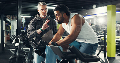Buy stock photo Exercise bike, man and coach in gym for fitness, help or workout for health. Cycling, personal trainer and training in sport club with instruction for spin class, cardio or wellness with flare