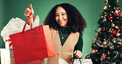 Buy stock photo Portrait, woman and bag in studio for Christmas celebration, gift giving and xmas discount. Smile, female person and festive with shopping package, holiday giveaway and present on green background