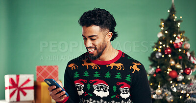 Buy stock photo Christmas, smile and man with mobile in studio for holiday, festive season or gift shopping. Xmas, phone and happy person with app to purchase present online, sale or discount on green background
