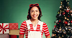Portrait, Christmas and woman with smile, studio and December holiday with decorations and presents. Excited, person and green background for Xmas season, celebration or tree with ornaments in USA