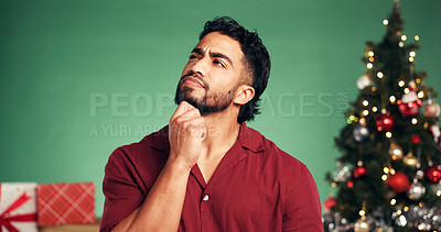 Buy stock photo Christmas, thinking and reflection with man in studio for decision, holiday season and gift planning. Festive tradition, future and space with person on green background for inspiration and vision