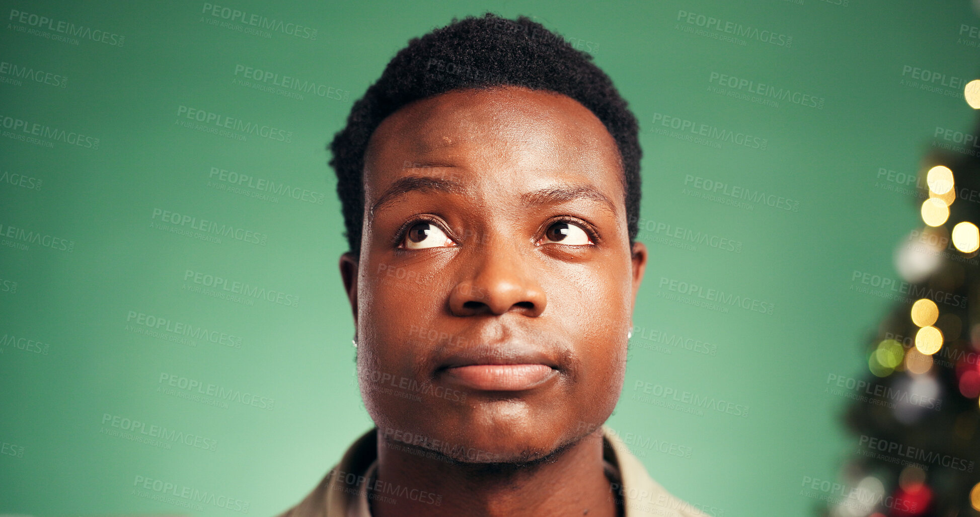 Buy stock photo Christmas, thinking and black man with ideas in studio for festive season, decision or gift planning. Xmas, reflection and person with thoughts for holiday, pensive or bokeh on green background space