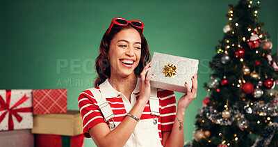 Buy stock photo Woman, Christmas in studio and laugh for gift, box and holiday with festive season on green background. Celebration, bokeh and female person happy for present, traditional tree or xmas package