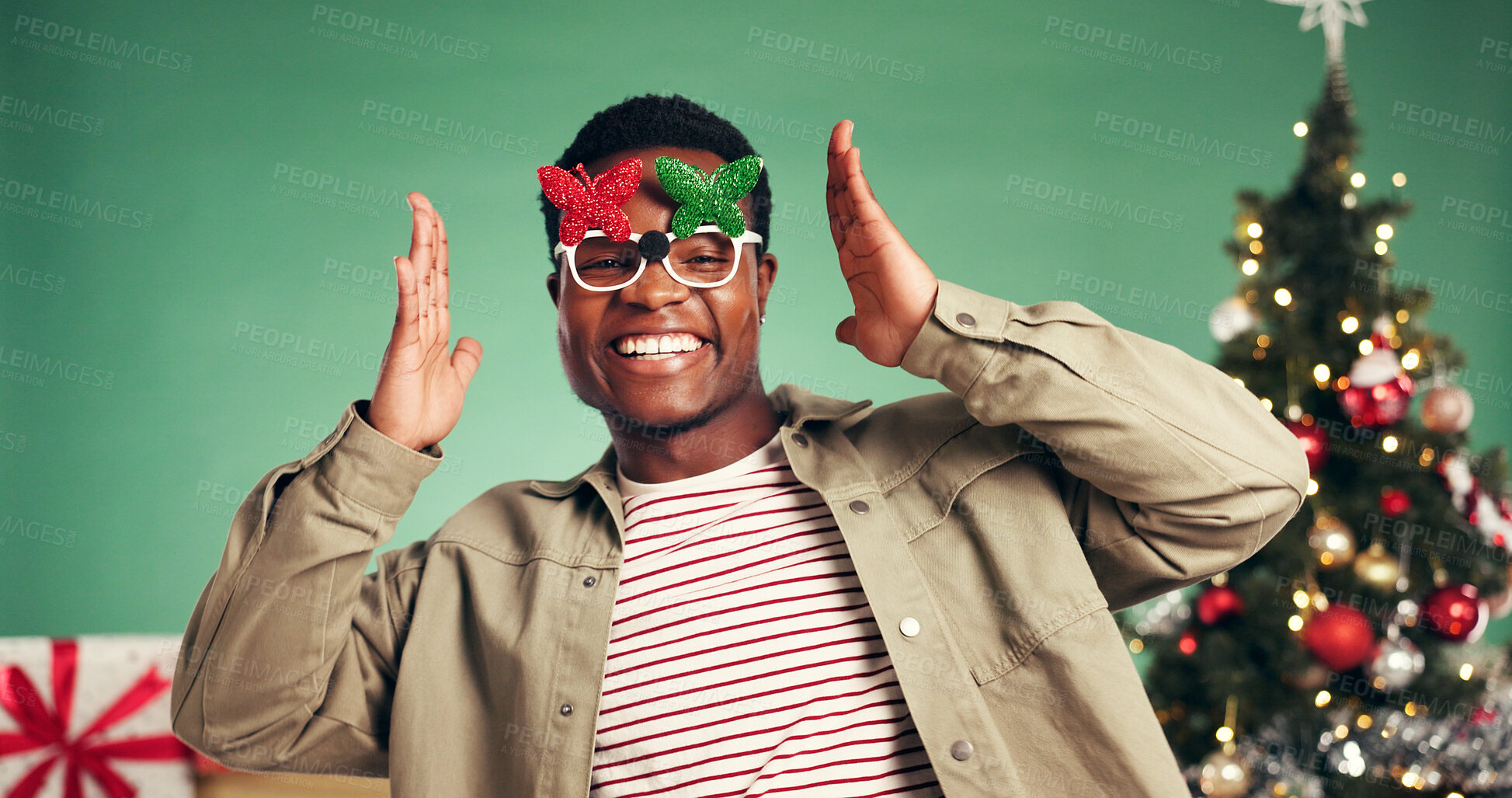 Buy stock photo Portrait, black man and dance in studio for Christmas holiday, xmas party and celebration. Smile, male person and sunglasses with music, moving rhythm and energy of festive season on green background