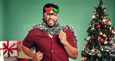 Buy stock photo Christmas, excited and man dance in studio for celebration at festive event on green background. Xmas sunglasses, happiness or person moving with portrait, holiday tradition or laugh with party music