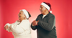 Christmas, dance and senior couple in studio for holiday, vacation and festive season. Mockup space, marriage and happy man and woman with energy, xmas celebration or December party on red background