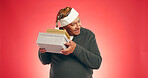 Christmas, elderly man or shake gift in studio for guess, surprise or giveaway in retirement. Senior person, smile or presents on red background space for festive season, Xmas tradition or secret