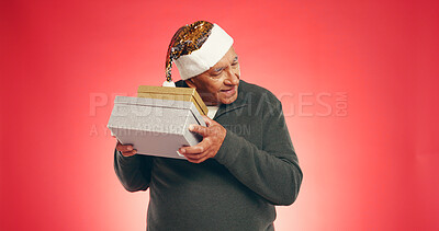 Buy stock photo Christmas, elderly man or shake gift in studio for guess, surprise or giveaway in retirement. Senior person, mockup or presents on red background space for festive season, Xmas tradition or secret