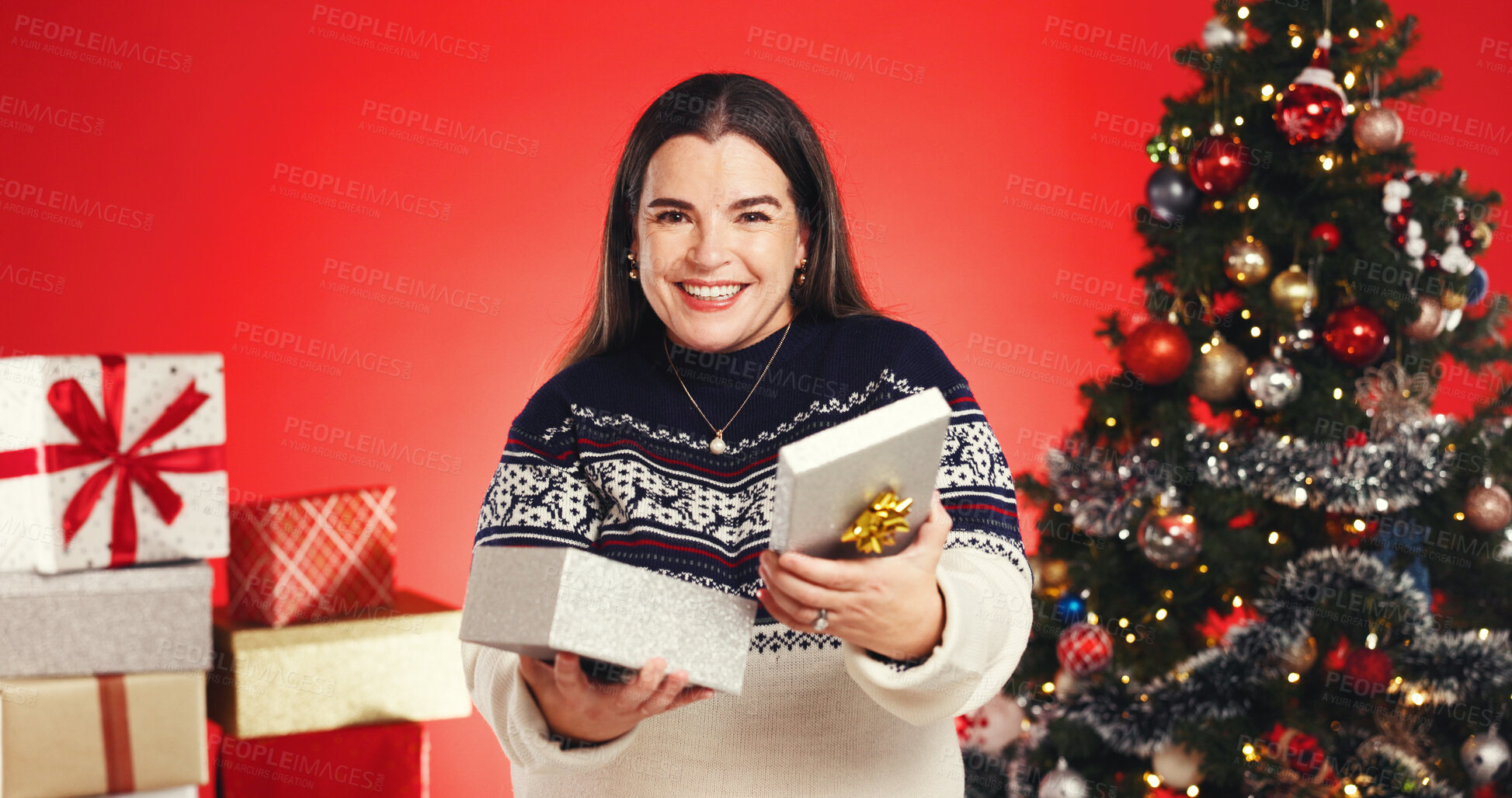 Buy stock photo Portrait, woman and gift in studio for Christmas holiday, surprise box and festive celebration. Smile, female person or package for xmas present, giveaway reward and tradition prize on red background