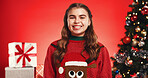 Portrait, child and happy for Christmas, studio or smile for December celebration or festive holiday. Red background, girl and excited with Xmas sweater, presents and tree with ornaments in USA