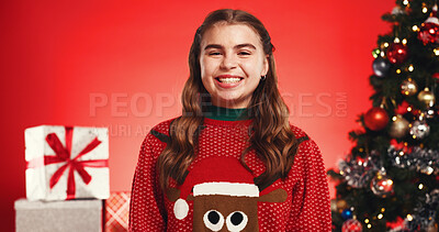 Buy stock photo Portrait, child and happy for Christmas, studio or smile for December celebration or festive holiday. Red background, teenager and excited with Xmas sweater, presents and tree with ornaments in USA