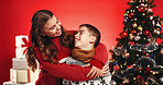 Christmas, hug and children with siblings for love, holiday celebration and festive season. Smile, connection and embrace for xmas with sister, brother and family vacation on red studio background