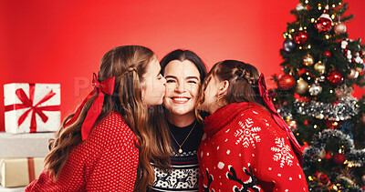 Buy stock photo Christmas, studio and mom with children, kiss or excited for December holiday, portrait and bonding. Red background, woman and happy with girls, love and kids with affection on Xmas season or tree