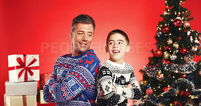 Buy stock photo Arms crossed, Christmas and smile of father with son in studio for celebration or tradition. Family, presents or tree with boy child and single parent man isolated on red background for holidays