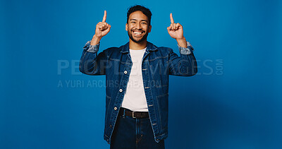 Buy stock photo Happy man, portrait and pointing up with space in studio for advertising on a blue background. Male person, model or marketing with smile, gesture or showing list for option, pick or choice on mockup