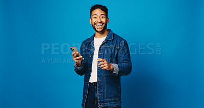 Buy stock photo Surprise, phone and portrait with man in studio for social media giveaway, communication and success. Online prize, happiness with person on blue background for space, winner and competition