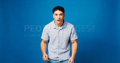Buy stock photo Man, surprise and portrait with reaction to news in studio, announcement or expression on blue background. Mockup space, wow or shock face with male person, alert or mindblown with notification