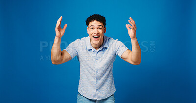 Buy stock photo Man, smile and surprise in studio portrait with good news, announcement or winning on blue background. Person, happy and excited with wow, shock and mock up space for deal, sale or prize in Colombia
