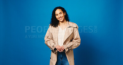 Buy stock photo Smile, portrait and woman with clothes for fashion, confidence and happy on mockup space. Casual, style and female model with trendy jacket, outfit and aesthetic on blue studio background in Brazil