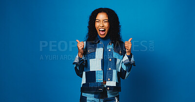 Buy stock photo Excited, woman and thumbs up for success with winner, goal or fashion sale on blue studio background. Happy, denim and like hand gesture for victory, celebration or trendy promo with mockup space