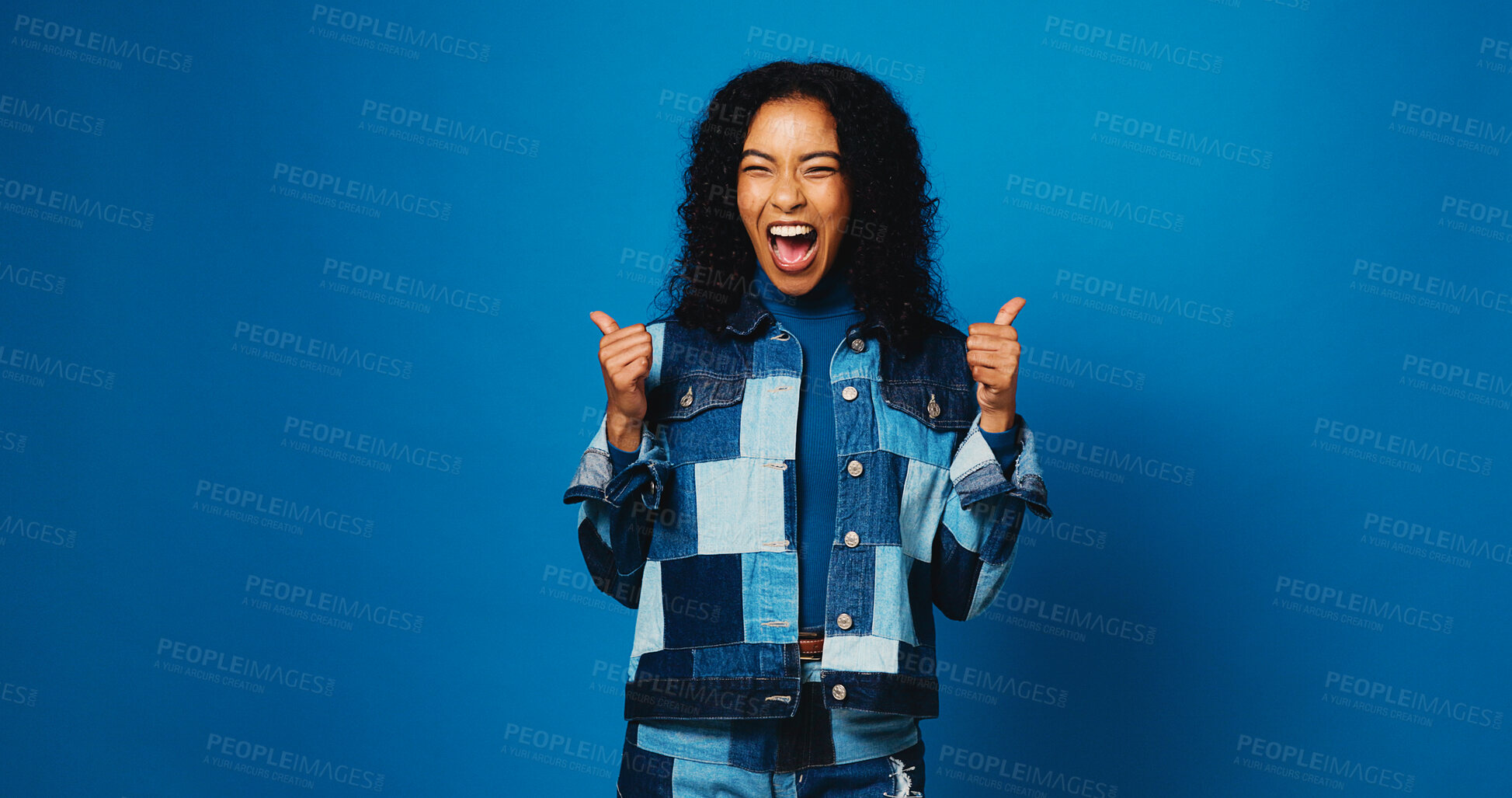 Buy stock photo Excited, woman and thumbs up for success with winner, goal or fashion sale on blue studio background. Happy, denim and like hand gesture for victory, celebration or trendy promo with mockup space