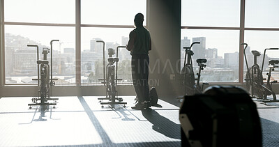 Buy stock photo Back, fitness and man thinking by gym window for reflection, wellness or view with stationary bike. Black person, health club and thoughts with exercise bicycle, workout planning or training decision