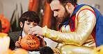 Halloween, help and father with son decoration and holiday with fun, drawing and family party. Bonding together, home and dad with child, learning and creative art with celebration  and pumpkin