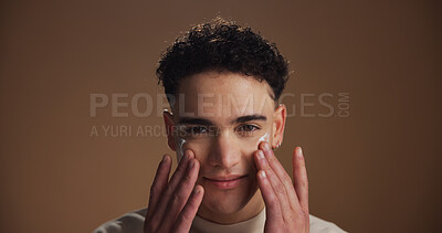 Buy stock photo Moisturizer, skincare and portrait of man in studio for beauty, natural or facial glow. Cosmetic, face cream and male person from Canada with lotion for dermatology routine by brown background.
