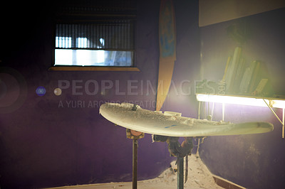 Buy stock photo Surfboard, dark room and dust in studio with fluorescent light, design and tools for repair. Craft, artistry and refinement in shaping workshop with sanding, maintenance or protection from sun damage