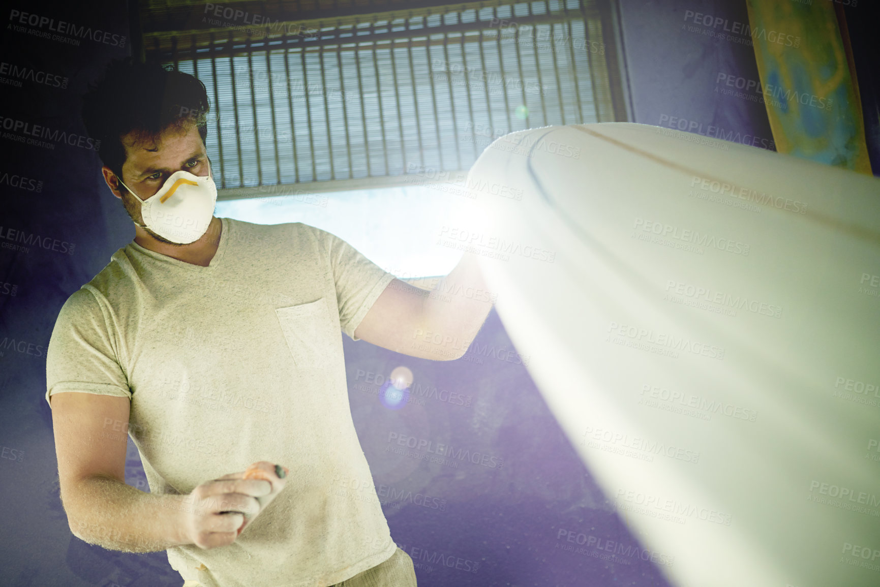 Buy stock photo Surfboard, craft and man with tool in workshop for manufacturing, custom design and shape material. Entrepreneur, handmade production and person with foam plank, safety mask or sanding in surf studio