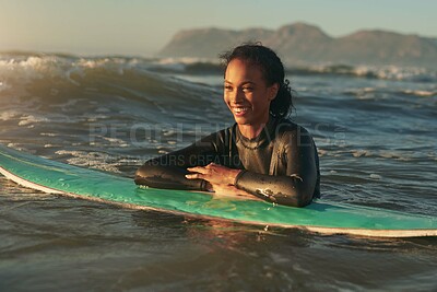 Surfboard, woman and swimming in ocean with wetsuit for summer adventure, sunset and fun hobby for waves. Girl, surfing sport and floating in water with board for vacation travel, relax and wellness