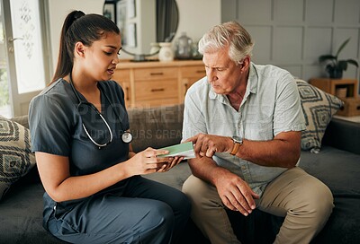 Buy stock photo Nurse, senior man and home care or consultation for healthcare and medicine prescription with a caregiver reading on medication box. Female medical worker talking to a old male sitting on a sofa