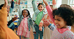 Children, excited or hands raised in celebration in classroom for recess, learning or end of school. Students, group and happy people at montessori with study break, education and development goals