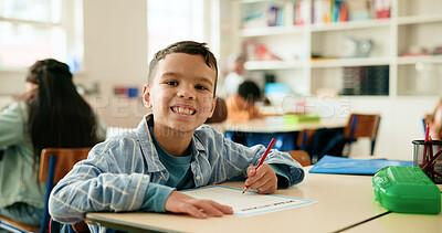 Buy stock photo Smile, writing and portrait of kid in classroom with confidence for education, learning or growth. Excited, student and face of boy child at elementary school for quiz, test or assessment at campus.
