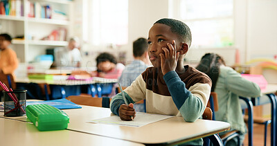 Buy stock photo Thinking, writing or boy in classroom for learning education, test paper or solution with students. Creative, quiz or smart kid at school for child development, assessment or knowledge evaluation