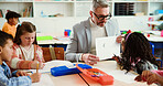Learning, drawing and teacher with kids in classroom for advice, sketch help and support. Education, teaching and art with group of students and man in school for child development and creative