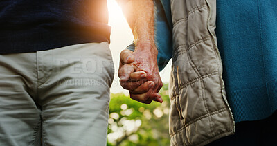 Buy stock photo Elderly couple, holding hands and walking with love in garden for commitment, loyalty or trust. Closeup, senior man or woman with lens flare in outdoor nature for bonding, safety or security together