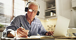 Elderly man, writing and headphones with laptop in home for retirement planning or asset management. Senior, male person or pensioner with notebook or computer for finance or investment in house