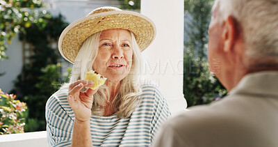 Buy stock photo Patio, old couple and bonding with fruit, home or conversation on weekend, wellness or healthy food. Outdoor, senior woman and elderly man with pineapple on break, romance and people with commitment