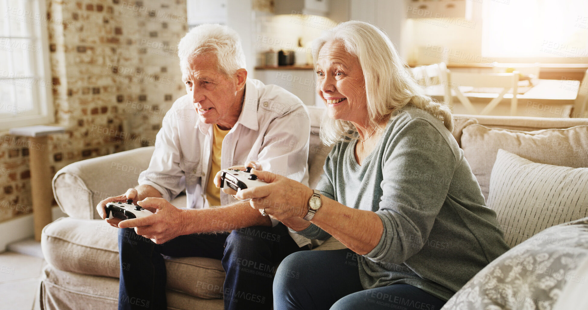 Buy stock photo Home, video game and senior couple on couch, bonding together and controller in lounge. Retirement, love and man with woman, entertainment and competition with hobby, smile and gaming with challenge