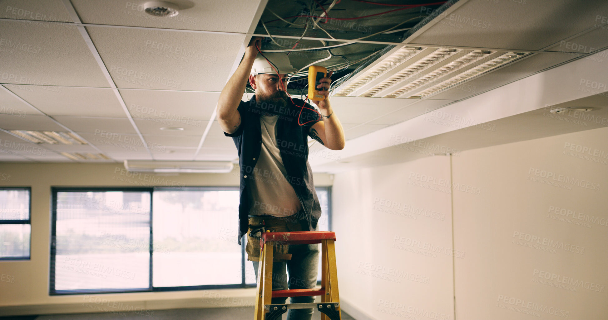 Buy stock photo Electrician, ceiling and man in office with wire, test or safety for quality control. Inspect, maintenance and technician in workplace with multimeter, assessment or voltage read in compliance check.