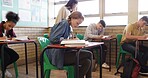 Girl, student and writing notes in classroom for education, task or quiz with development at academy. Teenager, high school kids and books for assessment, learning and problem solving for exam