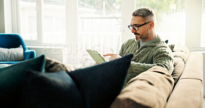 Buy stock photo Tablet, freelancer and mature man in home to review news, article or reading online. Technology, remote work and journalist in living room to check email for headline, story and research on internet