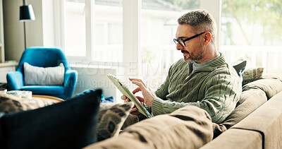 Buy stock photo Tablet, remote work and mature man in living room to review news, online or reading article. Technology, journalist and freelancer in home to scroll email for headline, story and research on internet